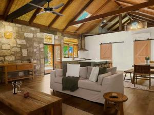 a living room with a couch and a table at Highwoods Cottage in Pokolbin