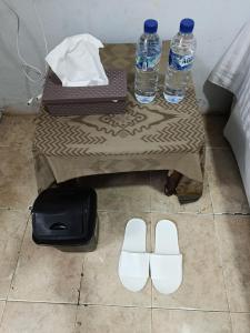 a table with two bottles of water and white shoes at River cliff guest house in Gunungsriti +15 photos