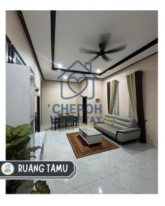 a living room with a couch and a ceiling fan at Chepoh Homestay Pasir Mas in Pasir Mas