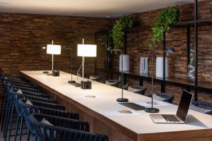 a long table with chairs and a laptop on it at Meliá Madrid Princesa in Madrid
