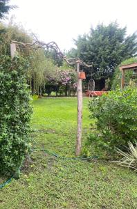 a wooden pole with a hose attached to it in a yard at Tiny House Marencalma in Santa Clara del Mar