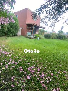 a yard with pink flowers in the grass at Tiny House Marencalma in Santa Clara del Mar