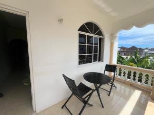 a balcony with two chairs and a table and a window at Serenity Escape in Runaway Bay