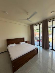 a bedroom with a bed in a room with sliding glass doors at SIORA Retreat in Dambulla