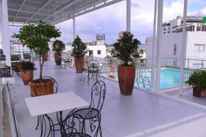 a balcony with tables and chairs on a building at Ciao SaiGon Hotel & Spa in Ho Chi Minh City