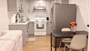 a kitchen with a black table and a refrigerator at Havre de paix in Fort Saskatchewan