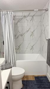 a bathroom with a tub and a toilet and a sink at Havre de paix in Fort Saskatchewan
