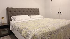 a bedroom with a large bed with a gray headboard at Havre de paix in Fort Saskatchewan