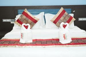 a bed with two heart pillows on top of it at MRM Grand Park in Pudukkottai