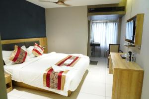 a hotel room with a bed and a television at MRM Grand Park in Pudukkottai