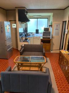a living room with a couch and a table at 釧路の夕日に近い宿トラベラーズイン南大通 in Kushiro