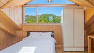 a bed in a room with a window at Yeongheungdo Rainbow Ocean View Pension in Incheon