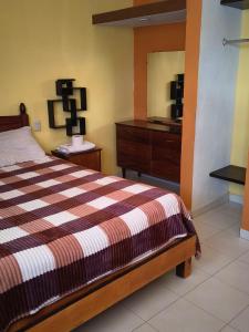 a bedroom with a bed and a dresser and a mirror at Casa Granada Jilotepec in Jilotepec
