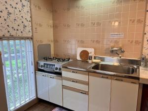 a kitchen with a sink and a stove at 伊豆ビーチクラブ in Shimoda