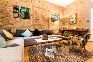 Una sala de estar con un sofá y una pared de ladrillos. en Urbana Hipster Downtown Budapest, en Budapest
