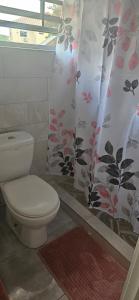 a bathroom with a toilet and a shower curtain at Hidden Gem in Happy Hill