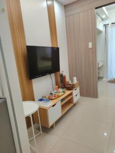 a living room with a television on a wall at VP luxury moa staycation in Manila