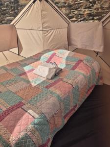 a quilt on a bed in a tent at Yourte in Saint-Germain-de-Calberte
