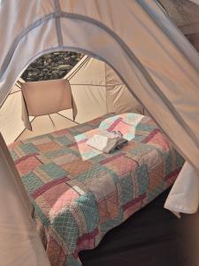 a bed in a tent with a blanket at Yourte in Saint-Germain-de-Calberte