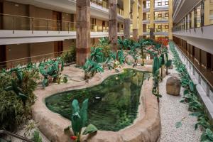 a large indoor pond in a building with plants at Holiday World Polynesia, Affiliated by Meliá in Benalmádena