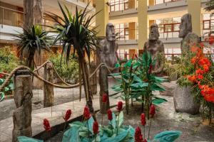 a garden with statues and flowers in front of a building at Holiday World Polynesia, Affiliated by Meliá in Benalmádena