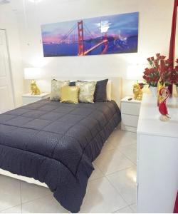 a bedroom with a large bed with a bridge painting on the wall at Private Miami Suite in Tamiami Airport