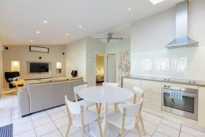 a kitchen with a white table and chairs in a room at Sandpiper On Smiths Lake in Smiths Lake