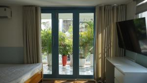 a bedroom with a sliding glass door to a patio at MAIAM Homestay in Ho Chi Minh City
