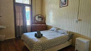a bedroom with a bed with a bag on it at Hotel Shakespeare Barcaldine in Barcaldine +20 photos