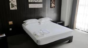 a bed with white sheets and pillows in a bedroom at Citylight Hotel in Baguio +185 photos