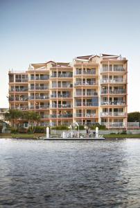 a large building with a boat in the water at On The River Apartments in Maroochydore