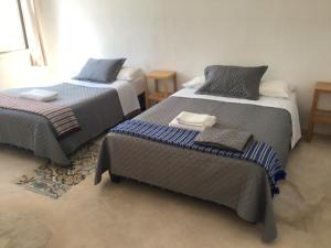 a room with two beds and two tables at Paz y Mar in Chelem