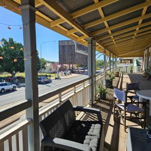 a patio with chairs and a table and a street at Hotel Shakespeare Barcaldine in Barcaldine