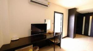 a living room with a desk with a tv and a televisionicter at U Style Hotel in Ban Phang Khwang Tai