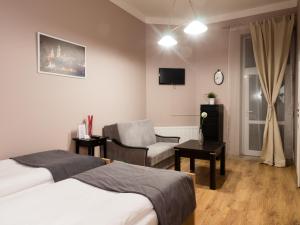 Una habitación de hotel con dos camas y una silla. en Just4You Apartments, en Cracovia