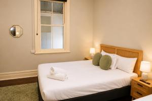 a bedroom with a bed with two pillows and a window at Geraldton Shoreline Lodge in Geraldton