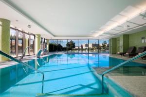 a large swimming pool with blue water in a building at Meliá Braga Hotel & Spa in Braga