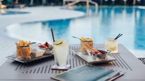 a table topped with plates of food next to a pool at Meliá Braga Hotel & Spa in Braga +43 photos