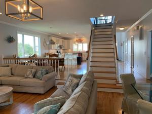 a living room with a staircase leading to a kitchen at Tortuga home in Holden Beach