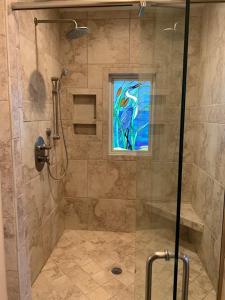 a bathroom with a shower with a stained glass window at Tortuga home in Holden Beach