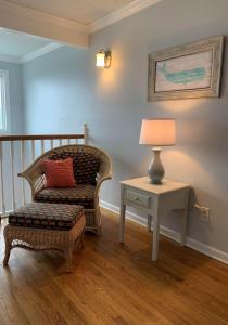 a room with a chair and a table with a lamp at Tortuga home in Holden Beach +26 photos