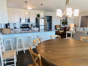 a kitchen and living room with a wooden table at Dune Deck North - Duplex in Holden Beach