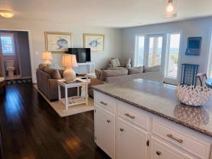 a living room with a couch and a table at Dune Deck North - Duplex in Holden Beach +45 photos