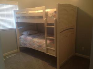 a bedroom with two bunk beds with a ladder at Dune Deck South - Duplex in Holden Beach