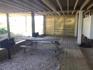 a picnic table and a grill in a building at Dune Deck South - Duplex in Holden Beach +5 photos