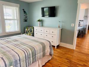 a bedroom with a bed and a tv on the wall at Holden R Breath in Holden Beach