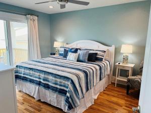 a bedroom with a bed with a striped blanket at Holden R Breath in Holden Beach +41 photos