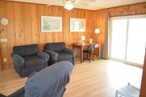 a living room with a couch and a chair and a desk at Do-Little Dock in Holden Beach
