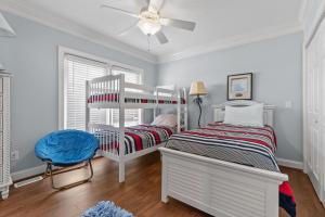 a bedroom with a bunk bed and a ceiling fan at Inn Between in Holden Beach