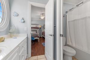 a white bathroom with a toilet and a crib at Inn Between in Holden Beach +51 photos